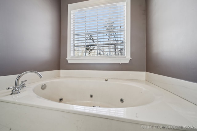 bathroom with a tub with jets