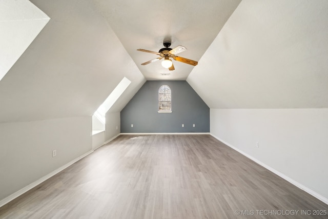 bonus room featuring lofted ceiling, ceiling fan, wood finished floors, and baseboards