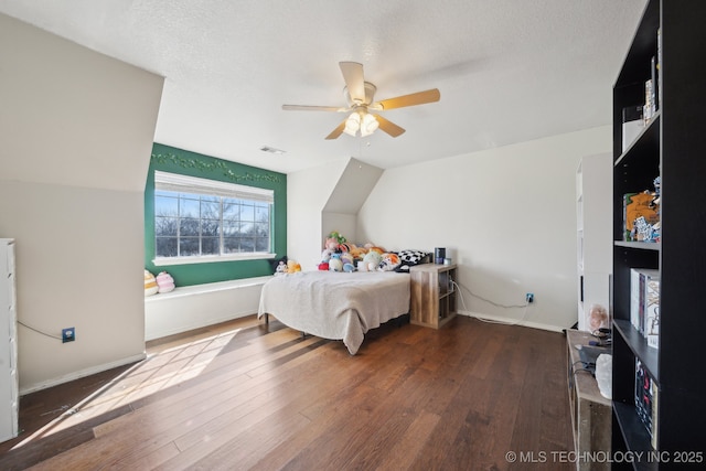 bedroom with ceiling fan, a textured ceiling, visible vents, baseboards, and wood-type flooring