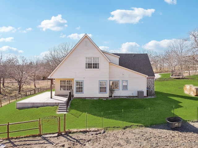 rear view of property featuring a shingled roof, a lawn, a gate, fence, and cooling unit