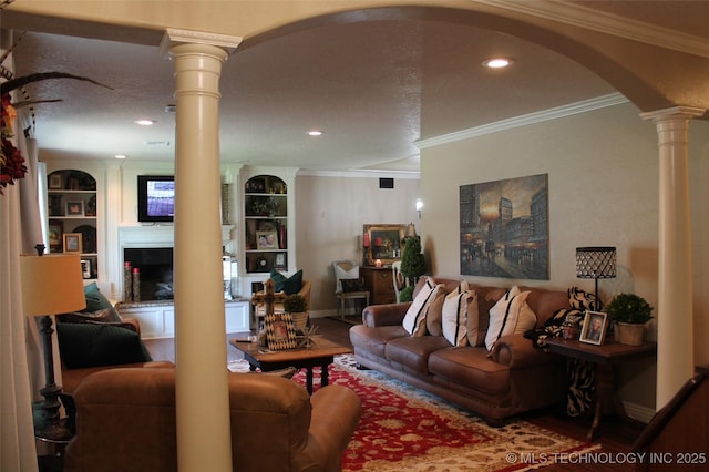 living room with arched walkways, decorative columns, a fireplace with raised hearth, ornamental molding, and baseboards