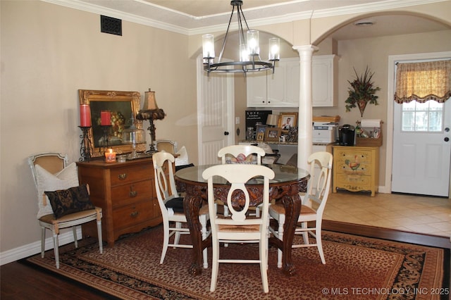 dining space with arched walkways, visible vents, baseboards, ornamental molding, and an inviting chandelier