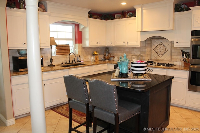 kitchen with white cabinetry, a sink, and light tile patterned floors