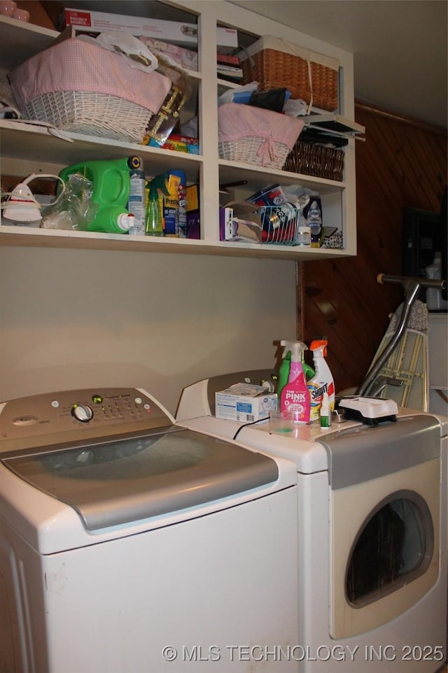 laundry area featuring laundry area, wood walls, and washer and dryer