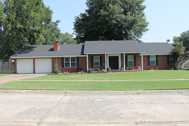 ranch-style house with concrete driveway, a chimney, an attached garage, a front lawn, and brick siding