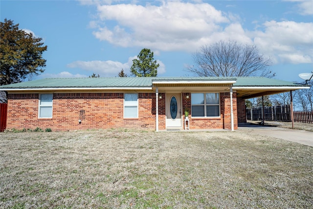 ranch-style home with metal roof, an attached carport, brick siding, fence, and concrete driveway