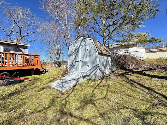 view of yard featuring an outbuilding, a wooden deck, and a storage shed