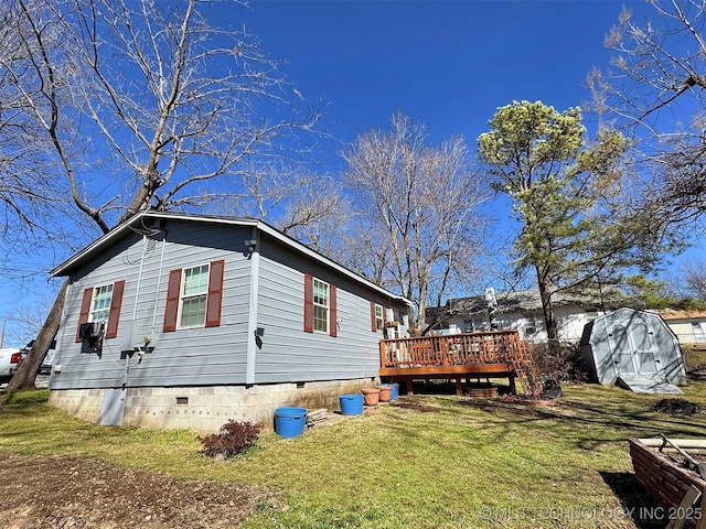 view of side of property featuring a deck, crawl space, and a lawn