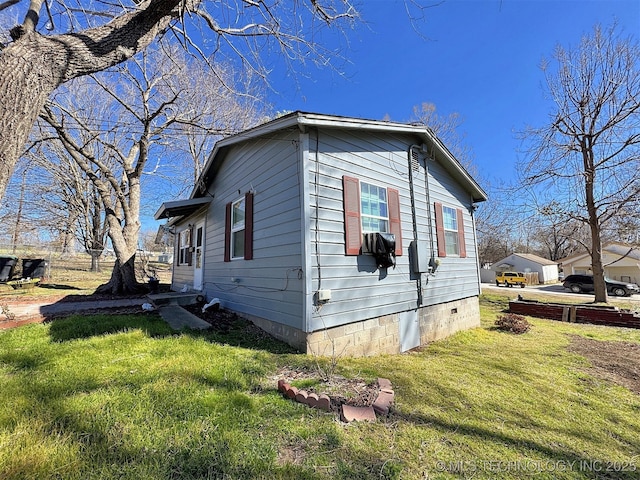 view of side of home featuring crawl space and a yard