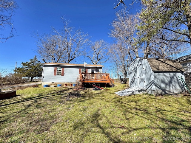 back of house featuring an outbuilding, crawl space, a lawn, a wooden deck, and a shed