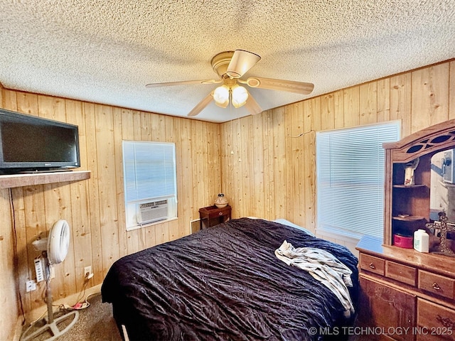 117 S Bluff Ave, Tahlequah, OK 74464 - carpeted bedroom with wooden walls, cooling unit, a textured ceiling, and ceiling fan