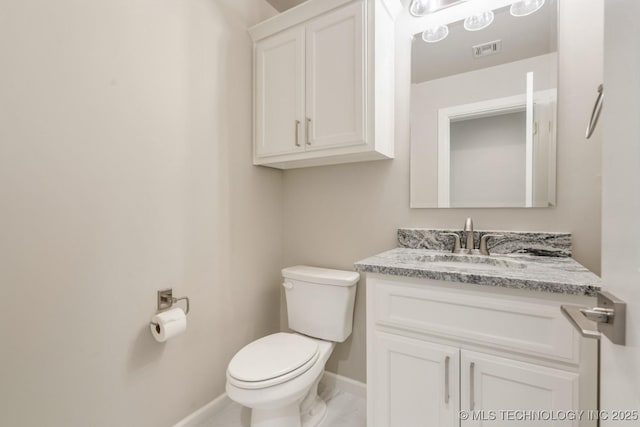 bathroom with toilet, baseboards, visible vents, and vanity