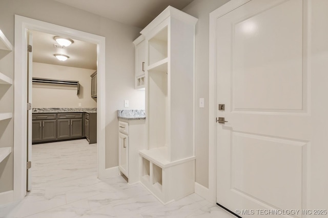 mudroom with baseboards and marble finish floor