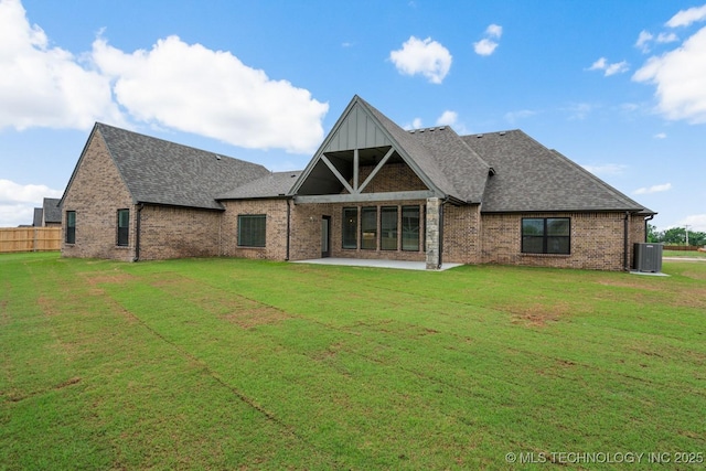 rear view of house featuring brick siding, central air condition unit, a yard, and a patio