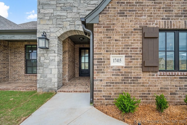 doorway to property with brick siding