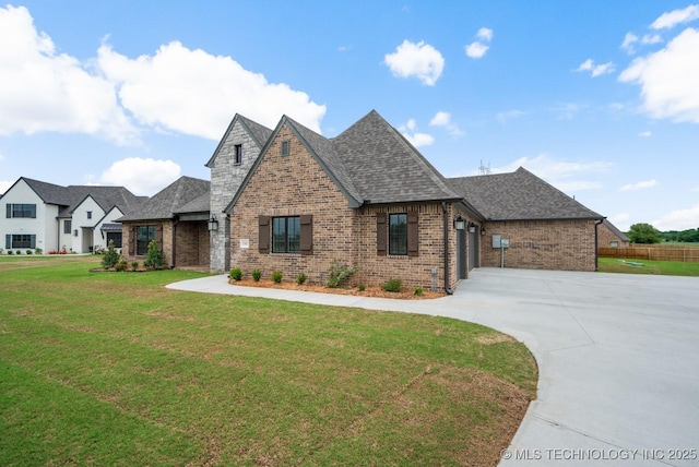 view of front of property featuring brick siding, an attached garage, driveway, and a front lawn