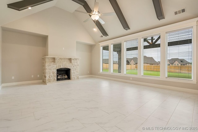 unfurnished living room with visible vents, marble finish floor, beamed ceiling, a stone fireplace, and high vaulted ceiling