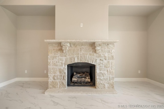 interior details with baseboards and a stone fireplace