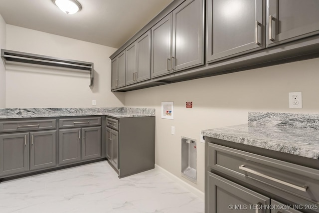 laundry room with baseboards, hookup for a washing machine, cabinet space, and marble finish floor