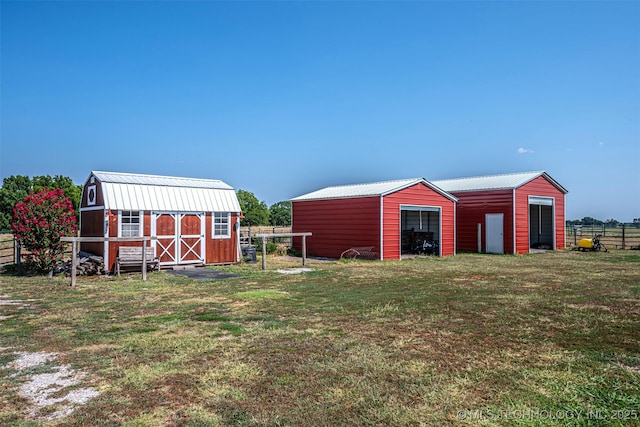 view of pole building featuring fence and a lawn