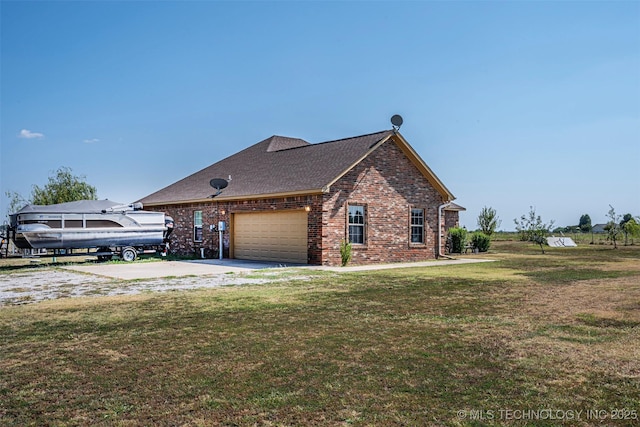 view of side of home featuring a yard, brick siding, a shingled roof, and driveway