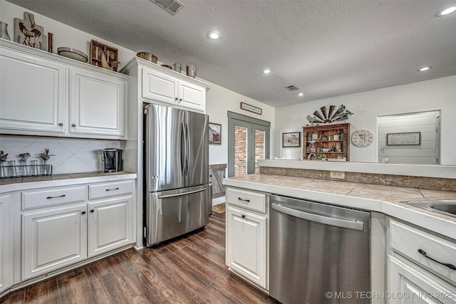 kitchen featuring french doors, visible vents, appliances with stainless steel finishes, dark wood-type flooring, and white cabinets