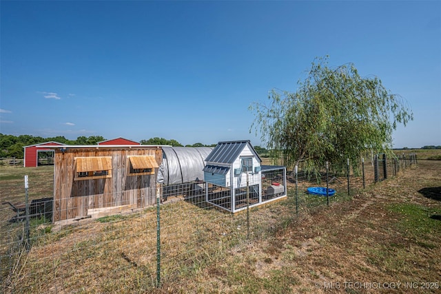 view of yard with an outbuilding, fence, and exterior structure