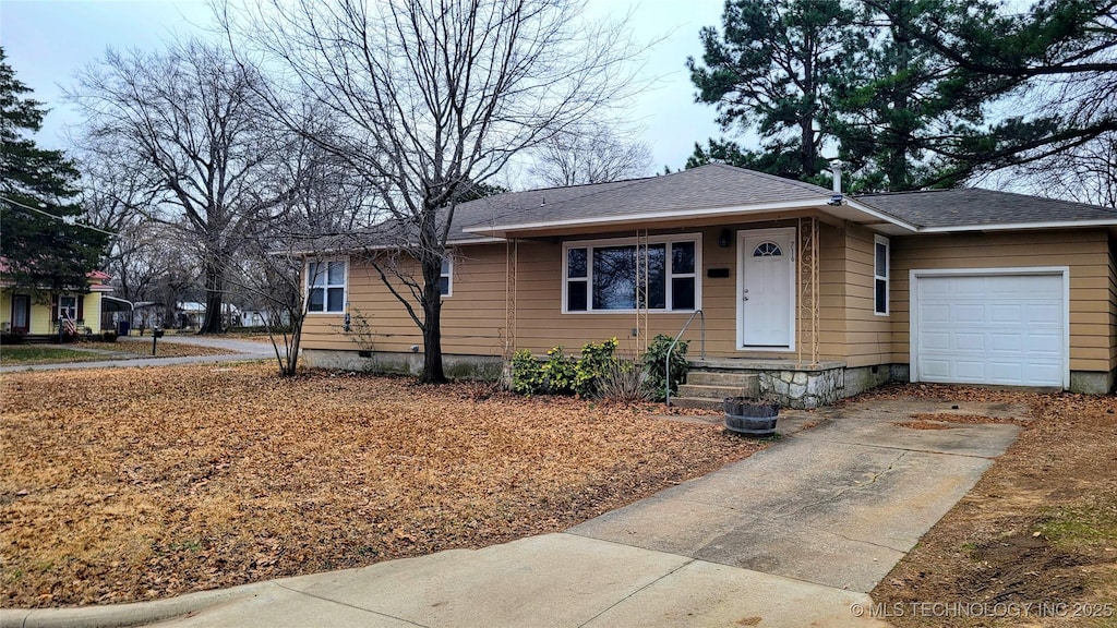 view of front of property featuring crawl space, driveway, a garage, and roof with shingles