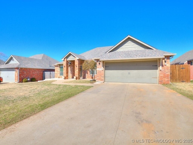 single story home with an attached garage, a front yard, fence, and brick siding