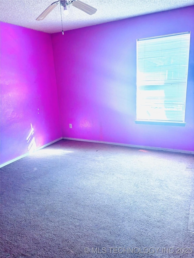 carpeted empty room featuring a ceiling fan and a textured ceiling