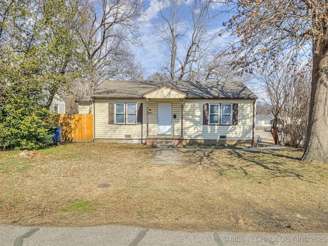 view of front of house with a front lawn, crawl space, and fence