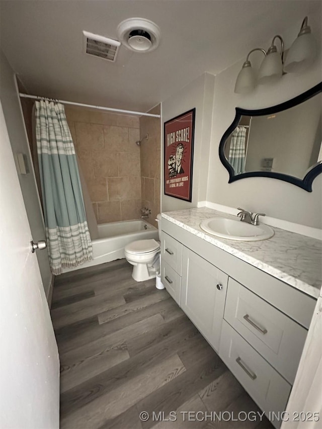 full bathroom with visible vents, toilet, shower / bath combo, wood finished floors, and vanity