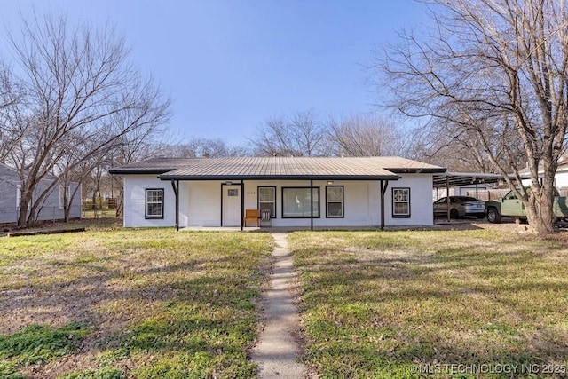 view of front of house with a carport, a front yard, covered porch, and metal roof