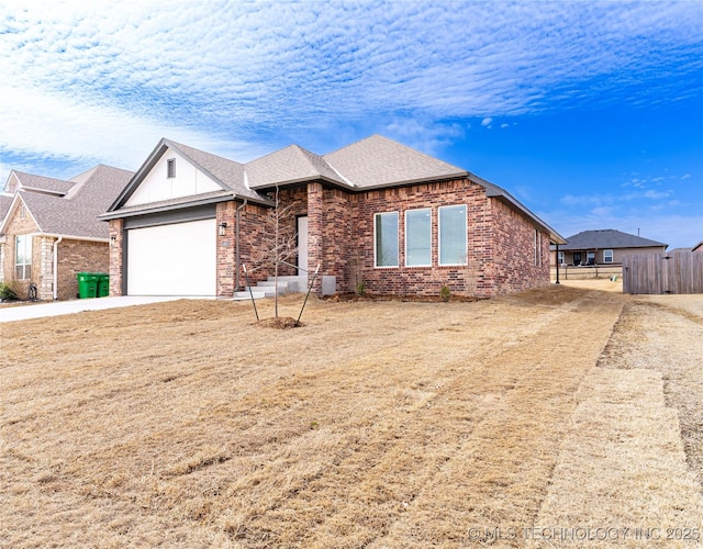 single story home featuring a garage, concrete driveway, brick siding, and fence