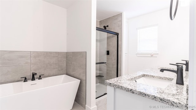 full bath with a stall shower, a freestanding tub, a sink, and double vanity