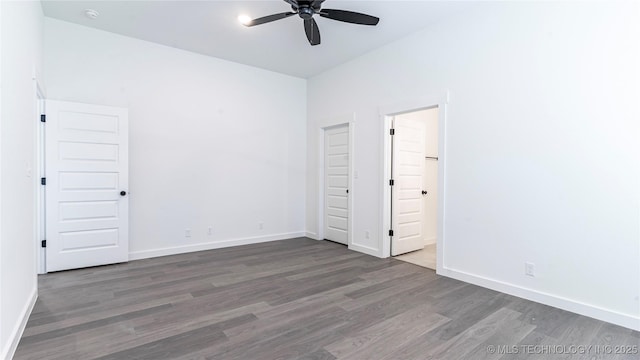 unfurnished bedroom featuring ensuite bathroom, wood finished floors, and baseboards