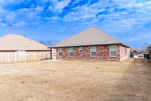 rear view of property with a patio area, brick siding, a fenced backyard, and roof with shingles