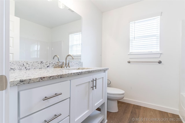 full bath featuring toilet, wood finished floors, visible vents, vanity, and baseboards