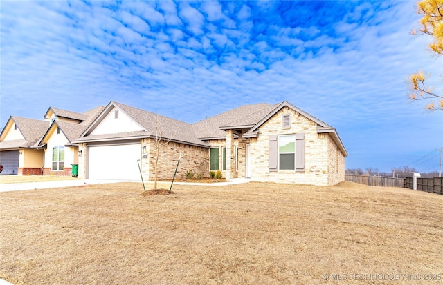 view of front of house with driveway, roof with shingles, an attached garage, fence, and brick siding