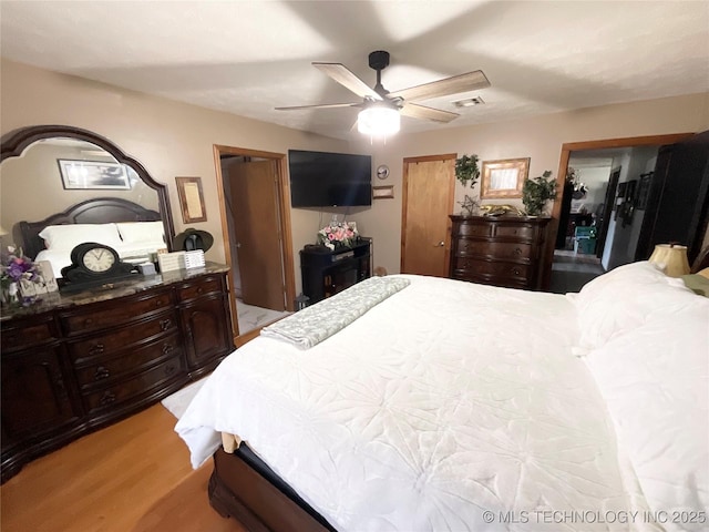 bedroom with light wood-type flooring, visible vents, and ceiling fan