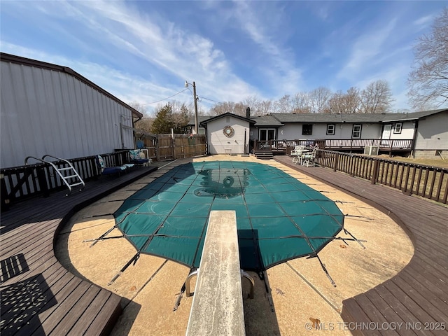 view of pool with a diving board, a fenced backyard, a wooden deck, and a fenced in pool