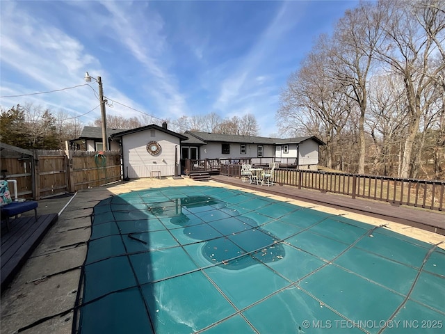 view of swimming pool featuring a wooden deck, a fenced in pool, and fence