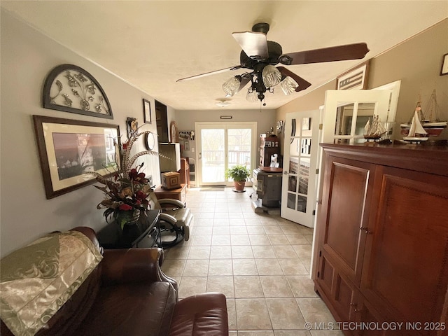 living area with light tile patterned floors and a ceiling fan