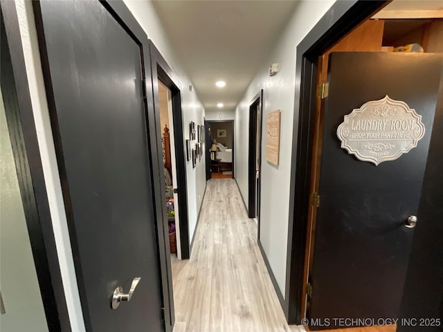 hallway featuring baseboards and light wood-style floors