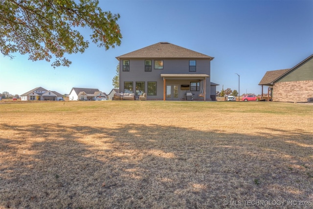 rear view of house featuring a lawn