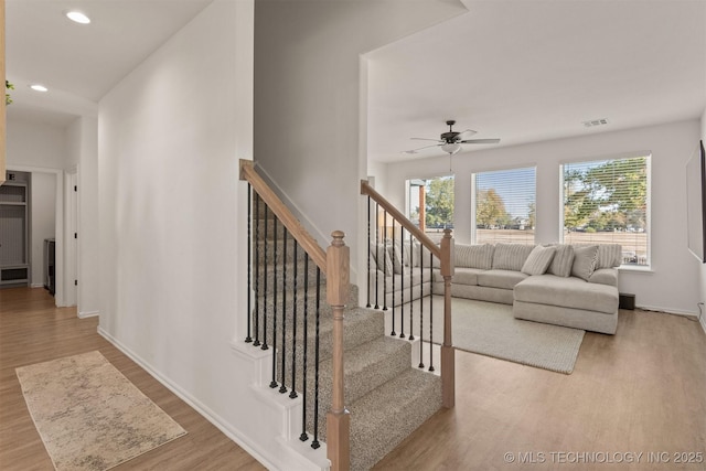 stairs with baseboards, wood finished floors, a ceiling fan, and recessed lighting