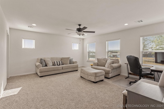 carpeted living area featuring baseboards, visible vents, and a ceiling fan