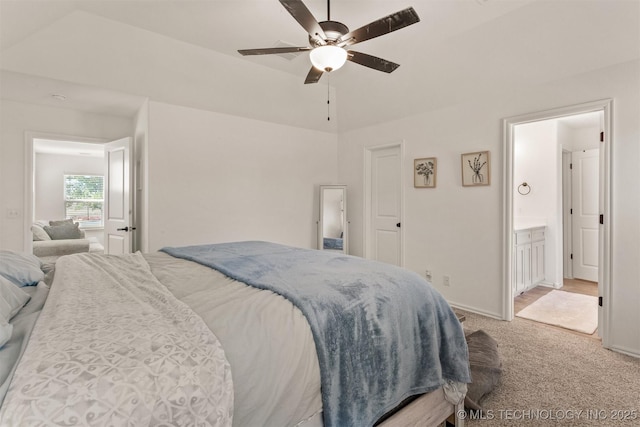 bedroom featuring light carpet, ensuite bathroom, a ceiling fan, and baseboards