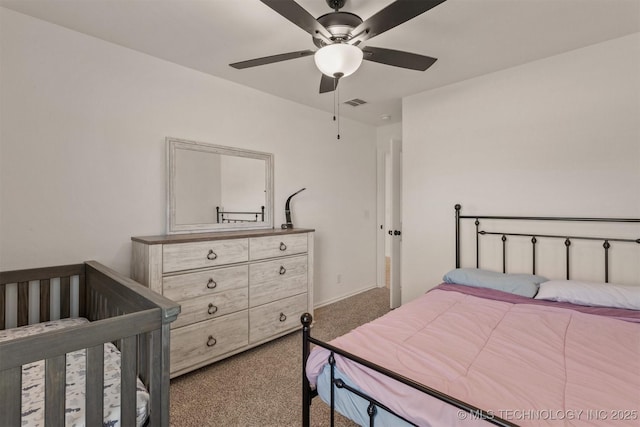 bedroom with carpet, visible vents, and a ceiling fan