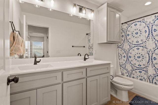 bathroom with toilet, shower / bath combination with curtain, double vanity, and a sink